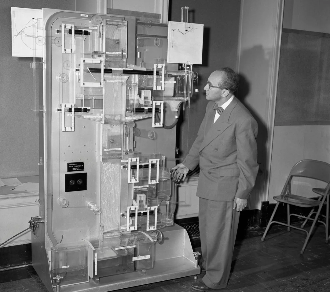 The MONIAC hydraulic computer - Bill Phillips standing next to his economic modelling machine